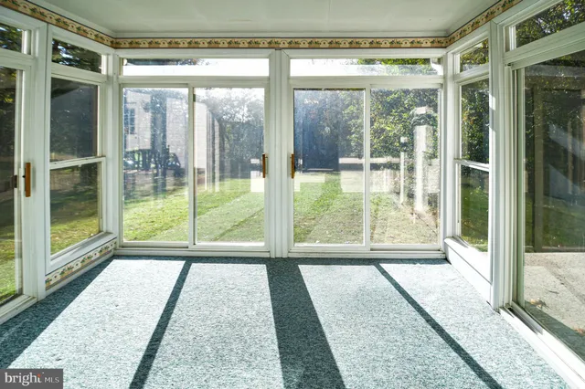 an empty room with windows and fireplace