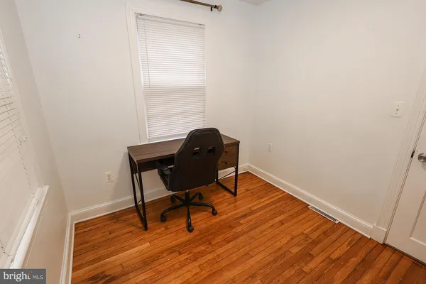 a view of a workspace with wooden floor and a window