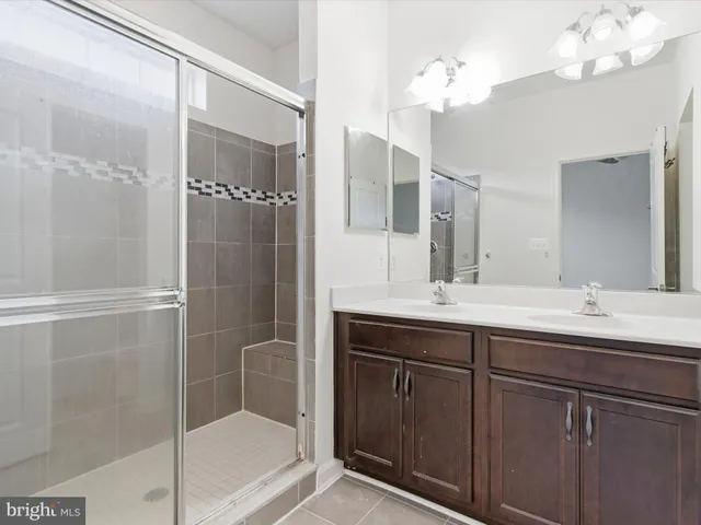 a bathroom with a double vanity sink mirror and shower