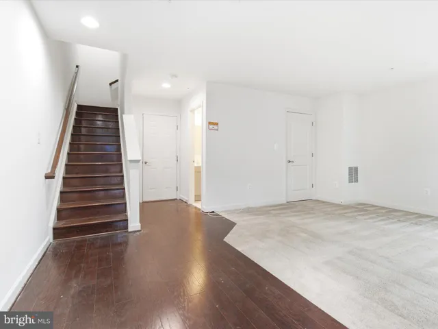 an empty room with wooden floor and entryway