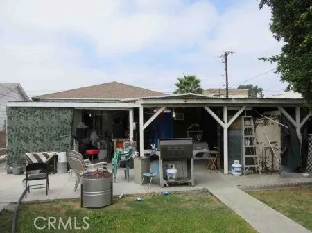 a view of a patio with table and chairs potted plants and floor to ceiling window