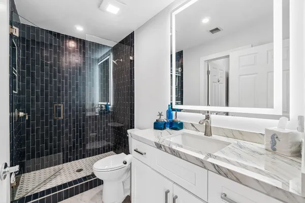 a bathroom with a sink a toilet and shower