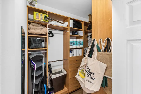 a view of walk in closet with clothes and shoes