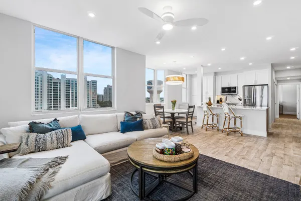 a living room with furniture and a view of kitchen