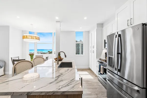 a kitchen with stainless steel appliances granite countertop a refrigerator and a sink