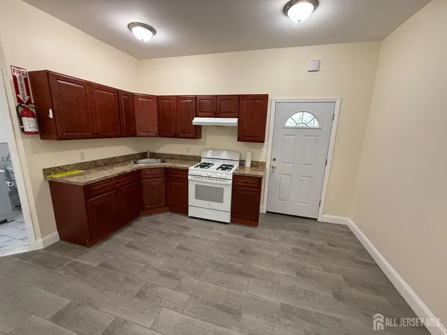 a kitchen with stainless steel appliances granite countertop a stove top oven sink and cabinets
