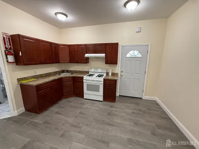 a kitchen with stainless steel appliances granite countertop a stove top oven and sink