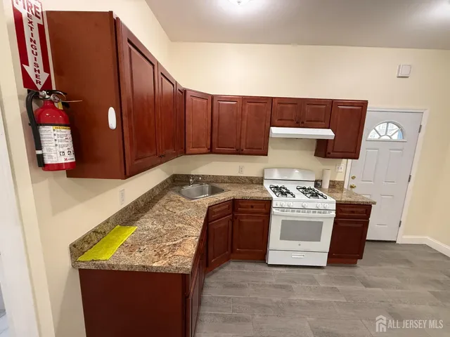 a kitchen with stainless steel appliances granite countertop a stove and a refrigerator