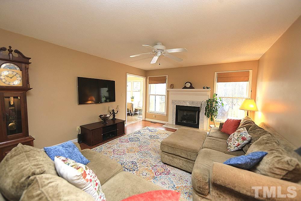 204 Lassiter Farm Road Raleigh, NC 27603 - Photo 8 of 30 The spacious living room has great wall space for furniture placement and an LP gas fireplace with marble surround.