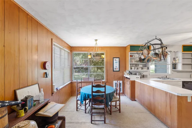 a dining room with furniture and a floor to ceiling window