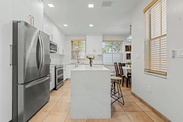 a kitchen with stainless steel appliances a refrigerator and a table