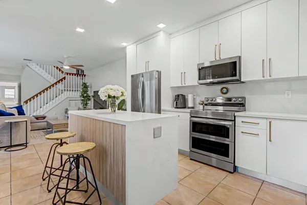 a kitchen with stainless steel appliances kitchen island granite countertop a refrigerator and a stove top oven