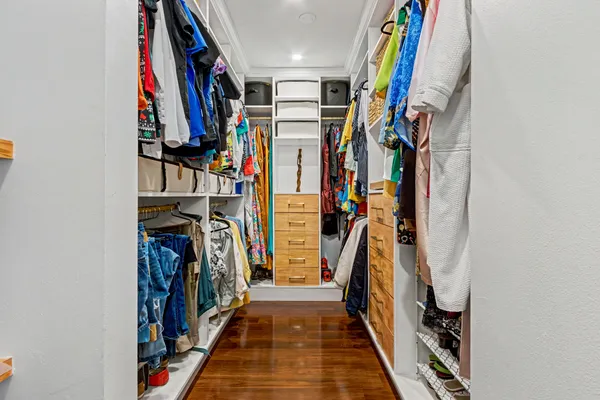 a view of walk in closet with clothes and shoes