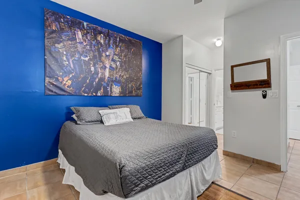 a bedroom with a large bed and a painting on the wall