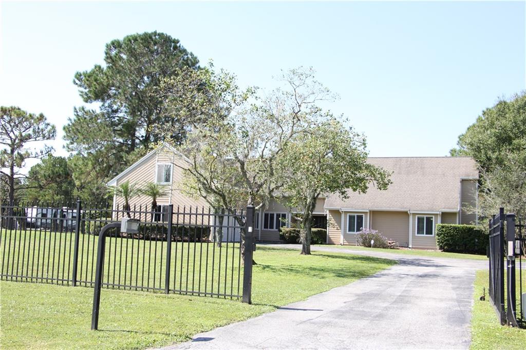17324 Whirley Road Lutz, FL 33558 - Photo 1 of 1 a front view of a house with a garden and deck