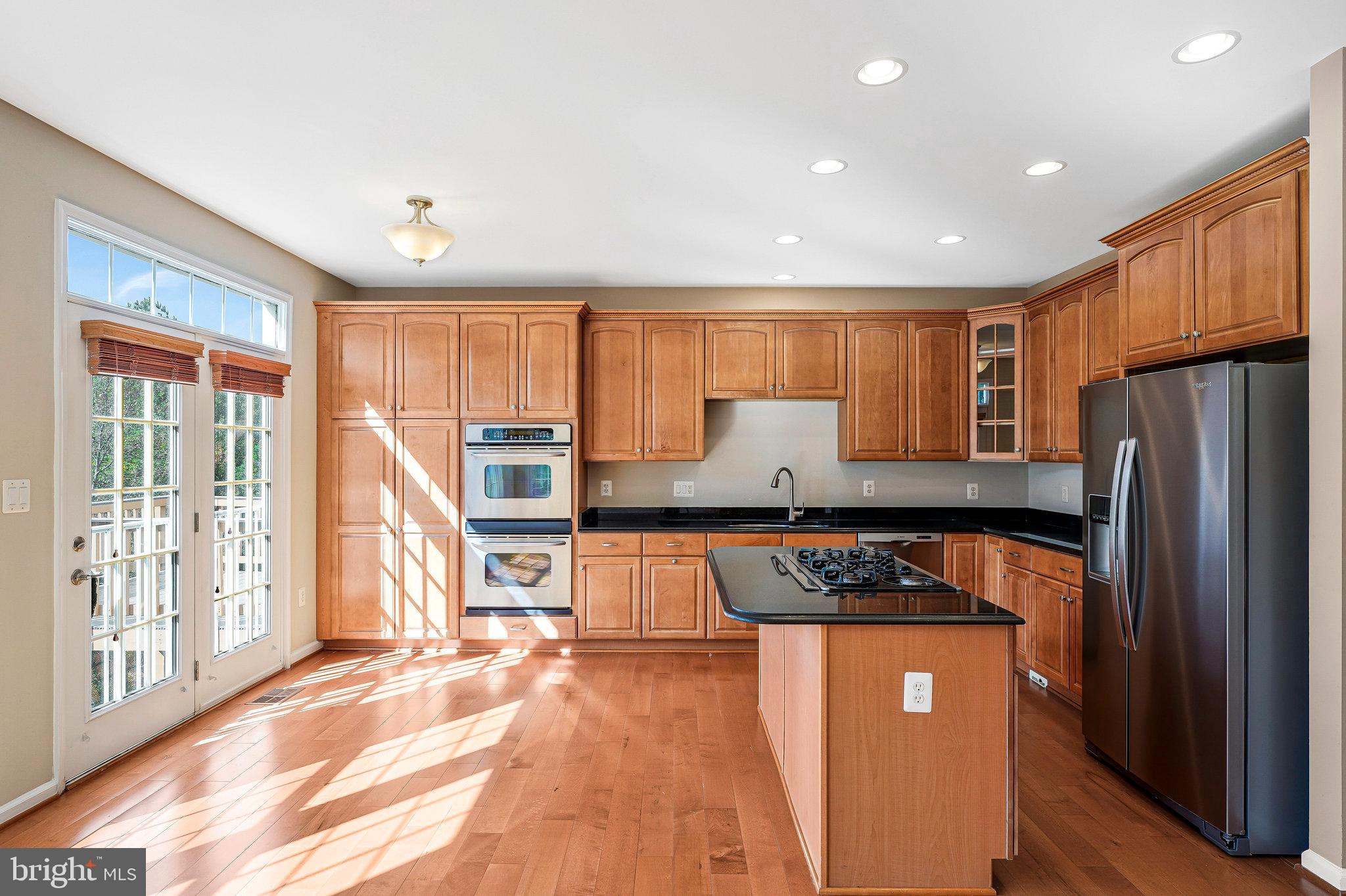 2478 Silk Court Herndon, VA 20171 - Photo 8 of 32 a kitchen with stainless steel appliances granite countertop a refrigerator a stove top oven and a sink with large window