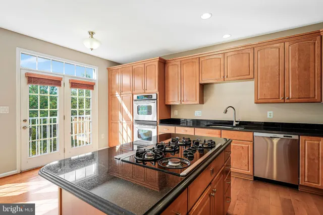 a kitchen with stainless steel appliances granite countertop a stove a sink and a refrigerator