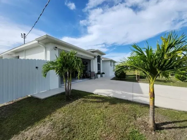 a view of a house with a yard and potted plants