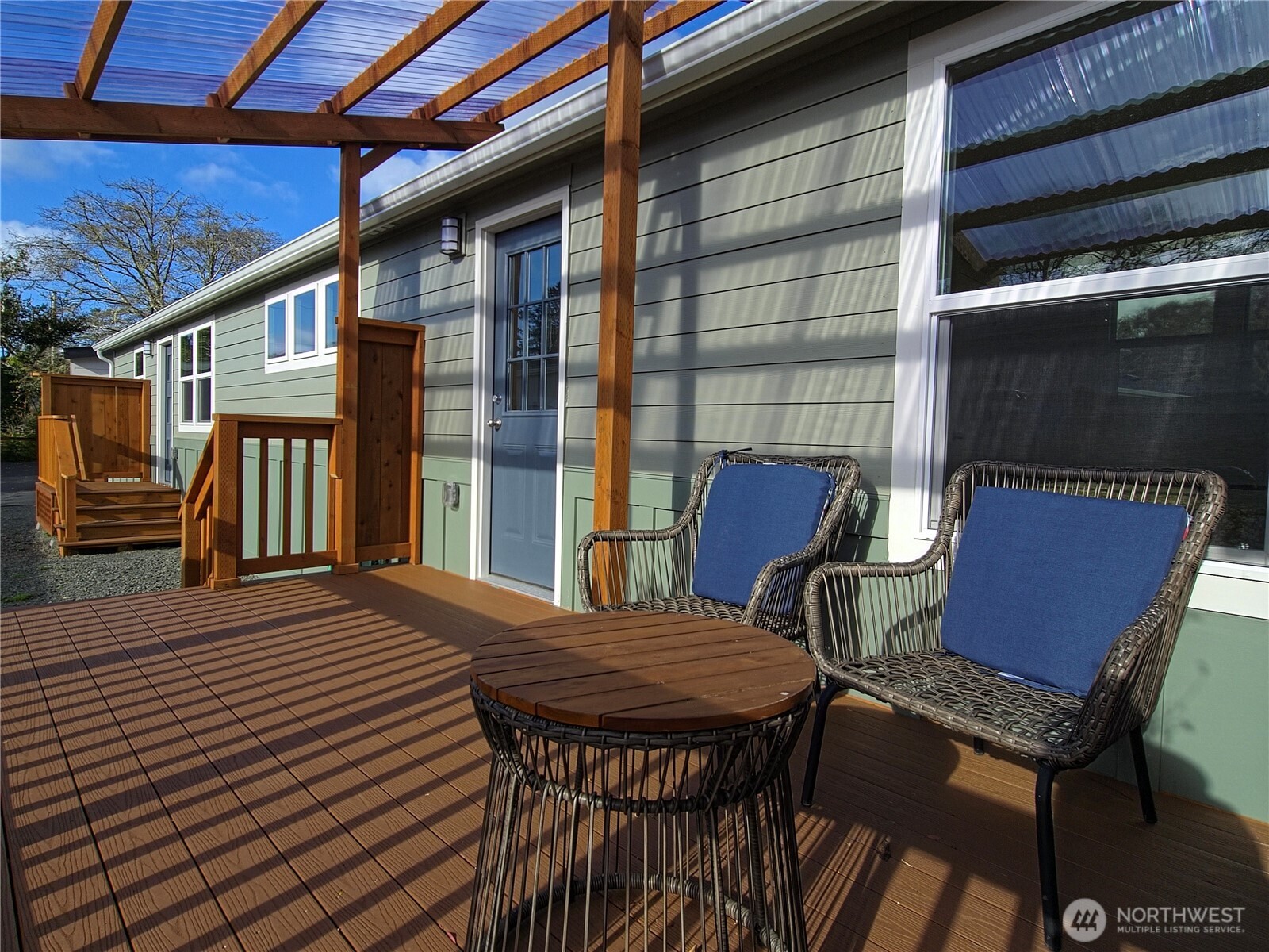 1303 30th Street, Unit 23 Seaview, WA 98644 - Photo 24 of 24 a view of a patio with table and chairs with wooden floor and fence