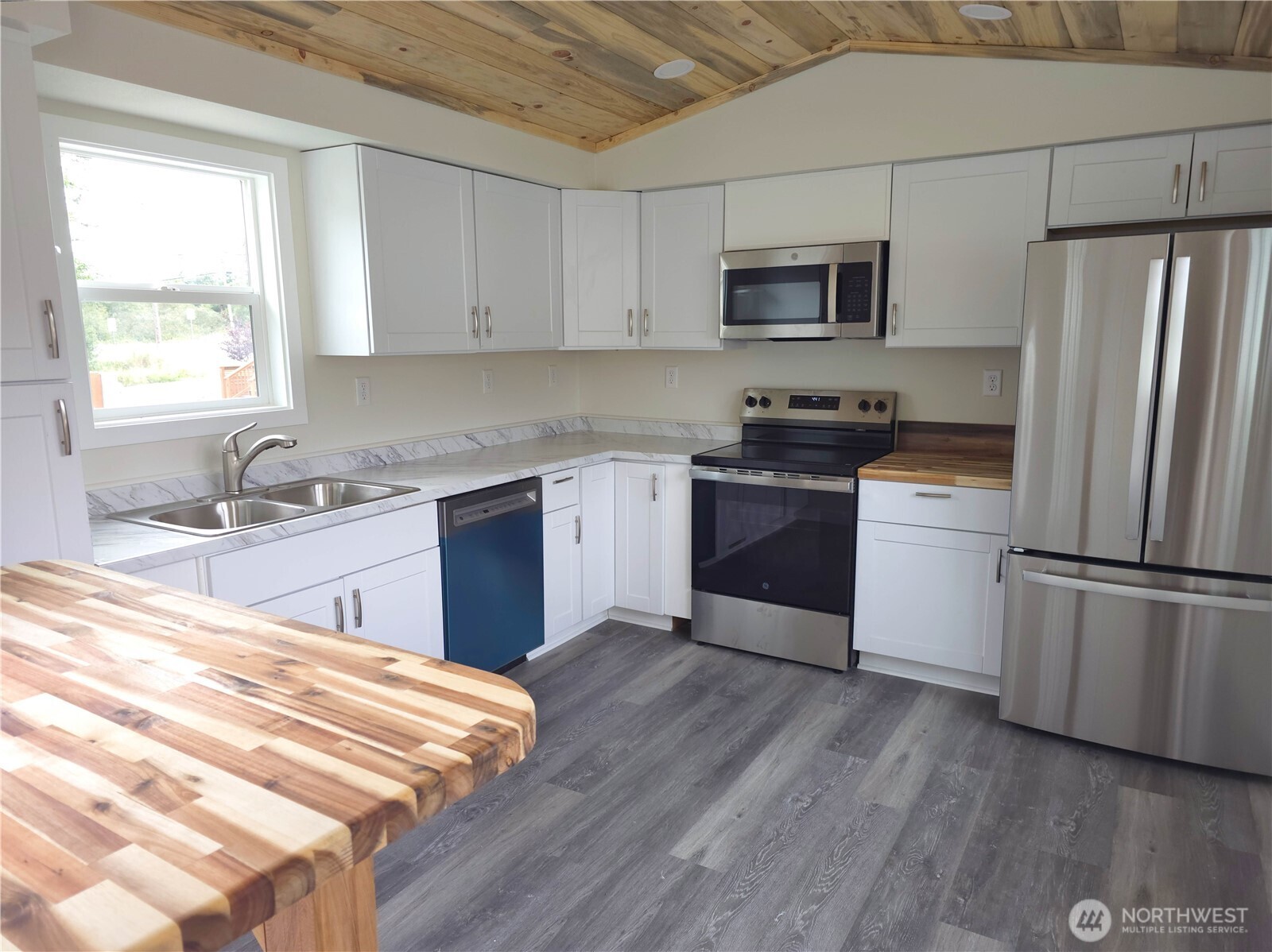 1303 30th Street, Unit 23 Seaview, WA 98644 - Photo 5 of 24 a kitchen with granite countertop stainless steel appliances and wooden cabinets