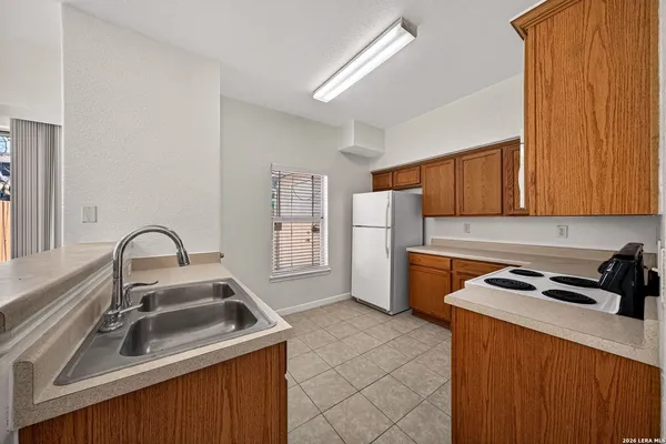 a kitchen with a sink a refrigerator and cabinets
