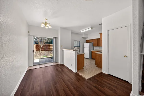a view of a kitchen with wooden floor and electronic appliances