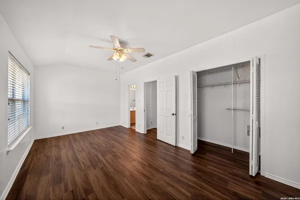 a view of a room with wooden floor and ceiling fan