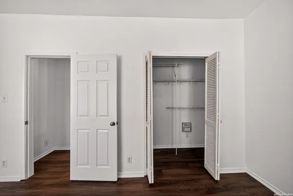 an empty room with wooden floor and closet