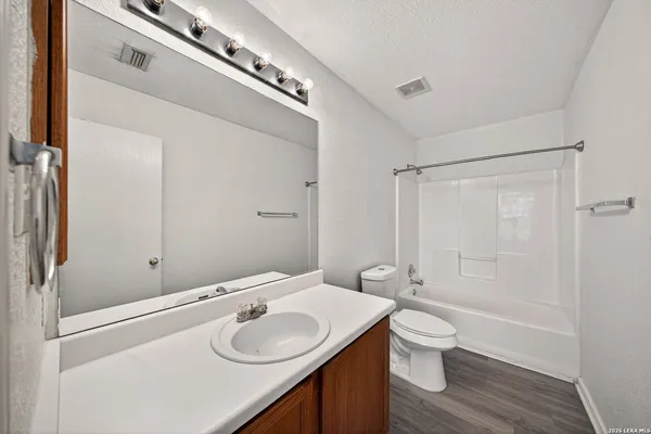 a bathroom with a granite countertop sink a toilet and shower