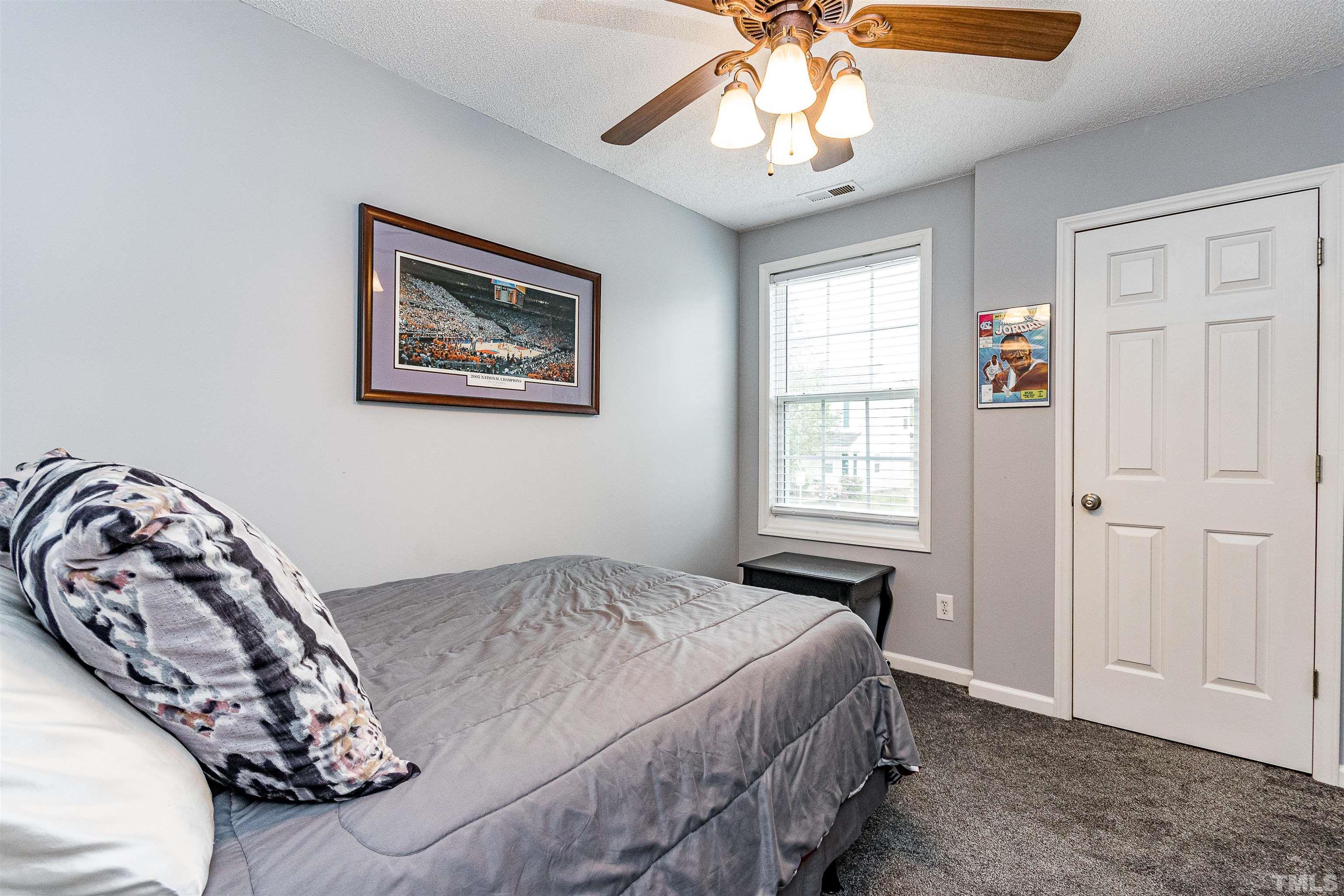 4924 Mocha Lane Raleigh, NC 27616 - Photo 13 of 16 a bedroom with a bed and a chandelier