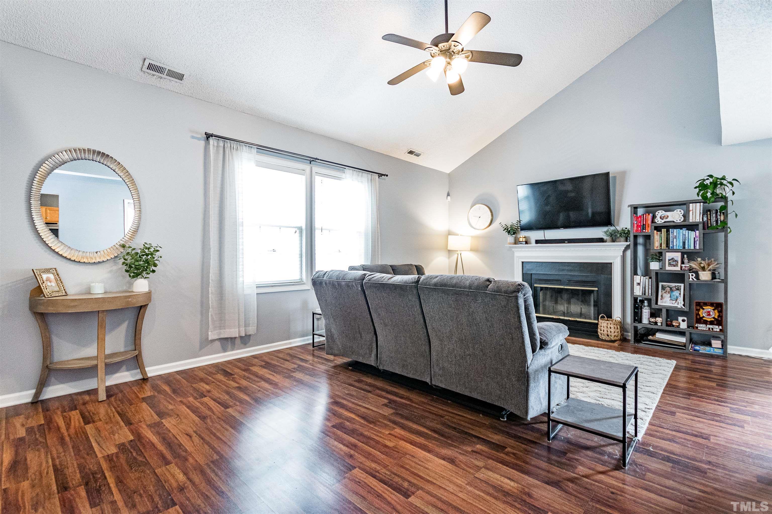 4924 Mocha Lane Raleigh, NC 27616 - Photo 2 of 16 a living room with furniture a fireplace and a flat screen tv