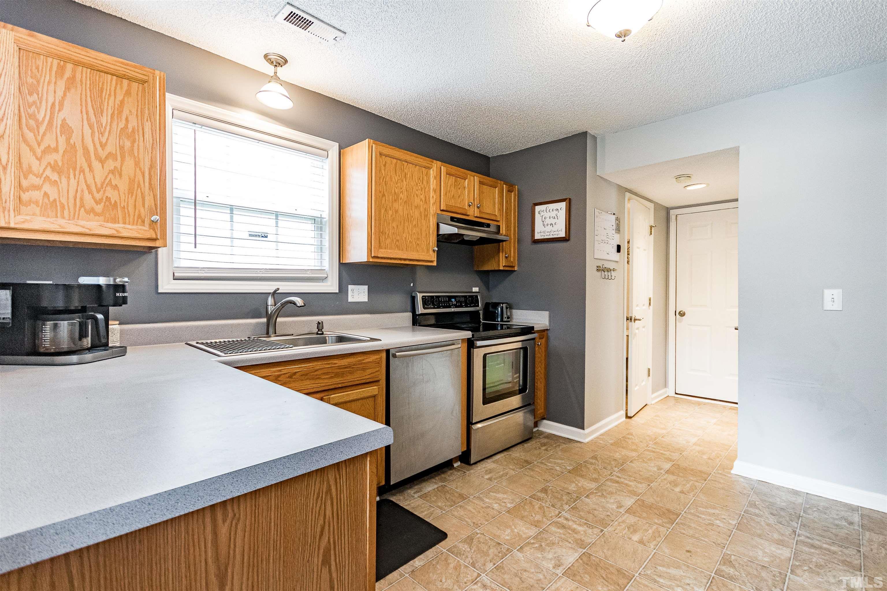 4924 Mocha Lane Raleigh, NC 27616 - Photo 7 of 16 a kitchen with a refrigerator a stove a sink and a microwave