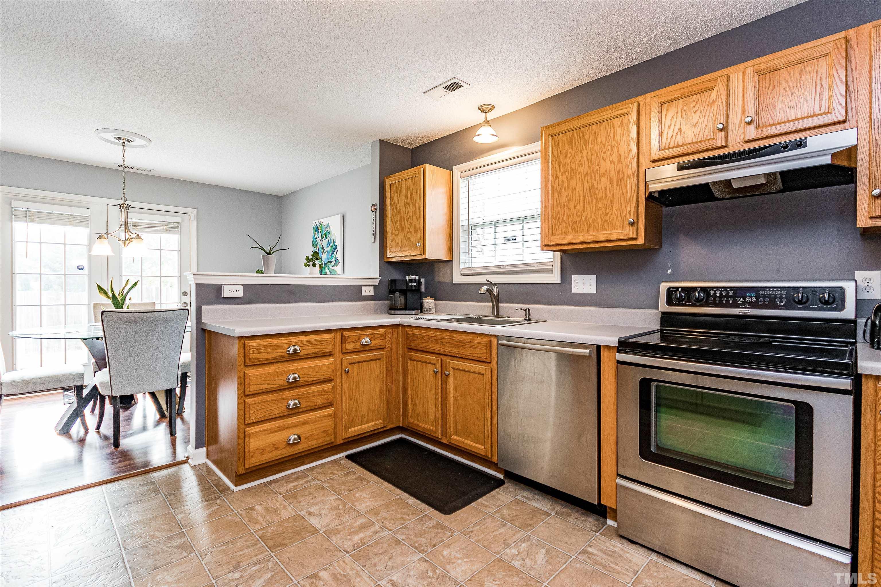 4924 Mocha Lane Raleigh, NC 27616 - Photo 8 of 16 a kitchen with stainless steel appliances granite countertop a stove a sink and a microwave