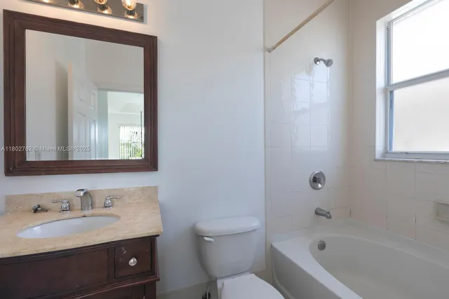 an empty room with wooden floor windows and exposed radiator