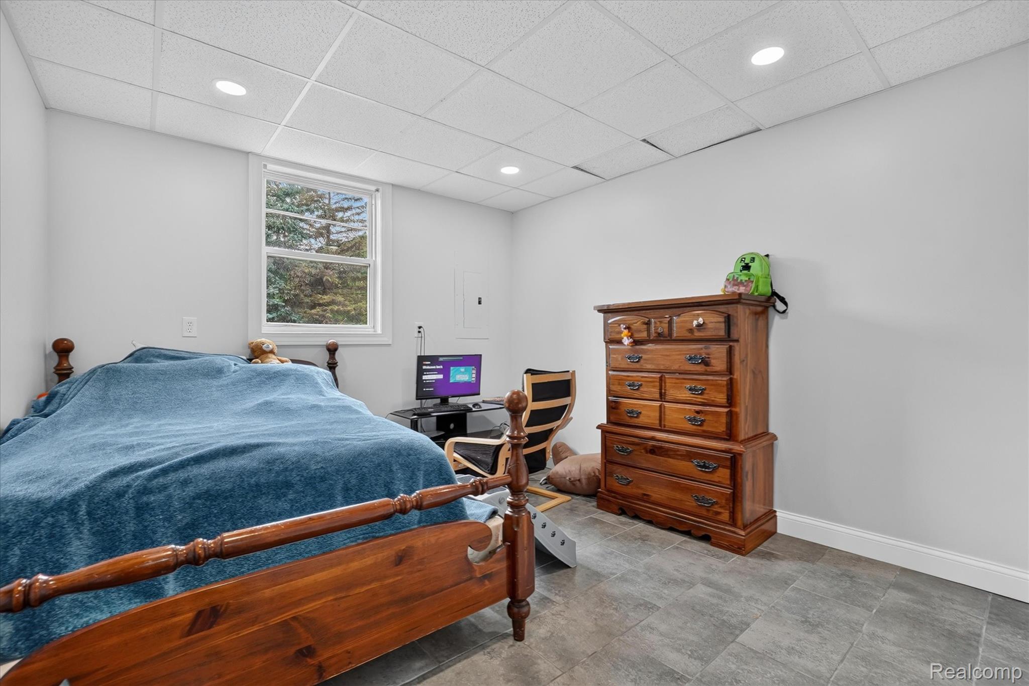 6524 Kelly Road Flushing, MI 48433 - Photo 22 of 47 Room featuring recessed lighting, a drop ceiling, light gray walls, a window with exterior views, and gray tile flooring