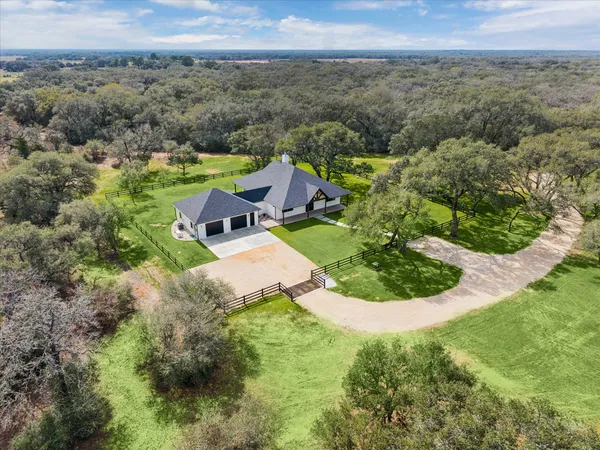 an aerial view of a house with big yard