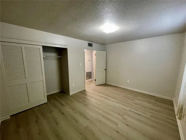 an empty room with wooden floor and closet