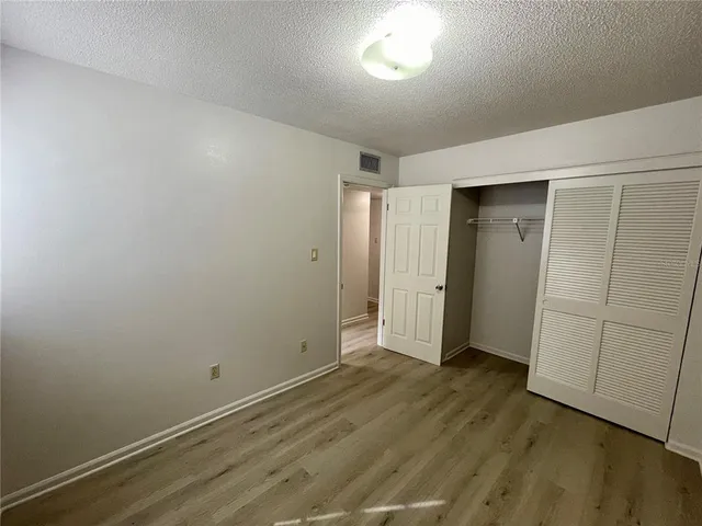 an empty room with wooden floor and closet
