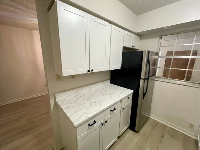 a kitchen with a stove refrigerator and microwave