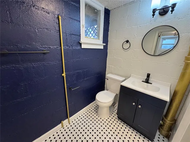 a bathroom with a toilet sink vanity and mirror