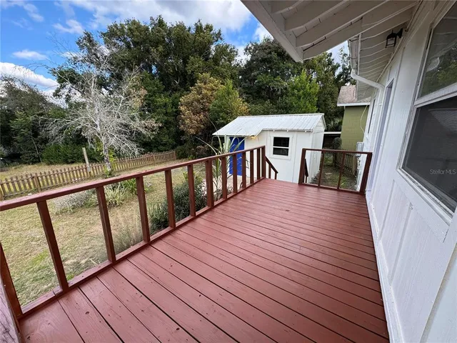a view of a deck with wooden floor and fence