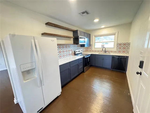 a kitchen with refrigerator and window