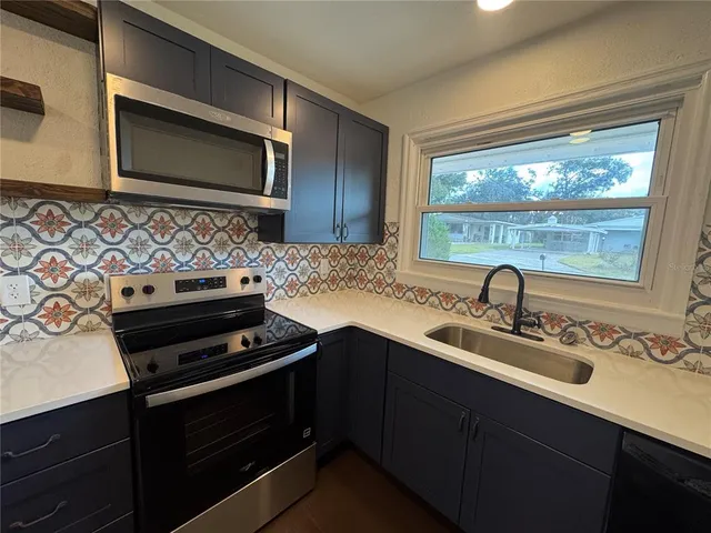 a kitchen with a sink stove and microwave