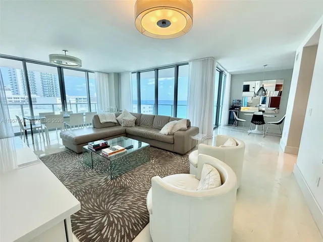a dining room with furniture and a floor to ceiling window