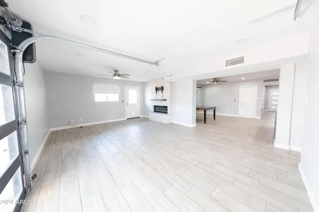 a living room with stainless steel appliances furniture a window and a kitchen view
