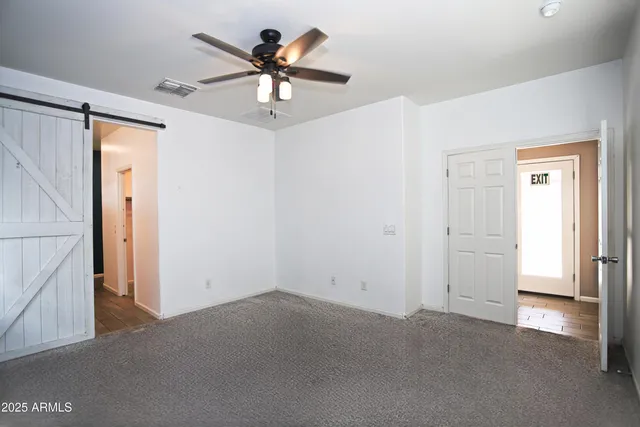 a view of a room with a ceiling fan and a window