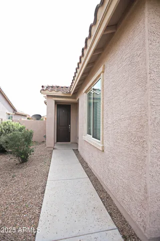 an empty room with kitchen and hardwood floor