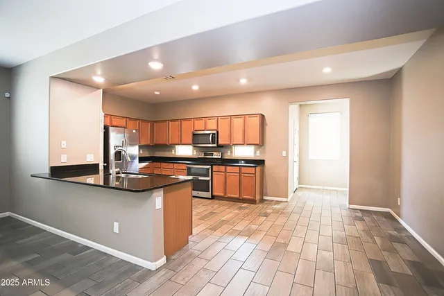 a kitchen with stainless steel appliances granite countertop a refrigerator a stove a sink and a microwave