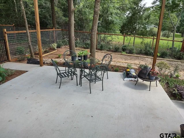 a view of a patio with a table chairs and a backyard