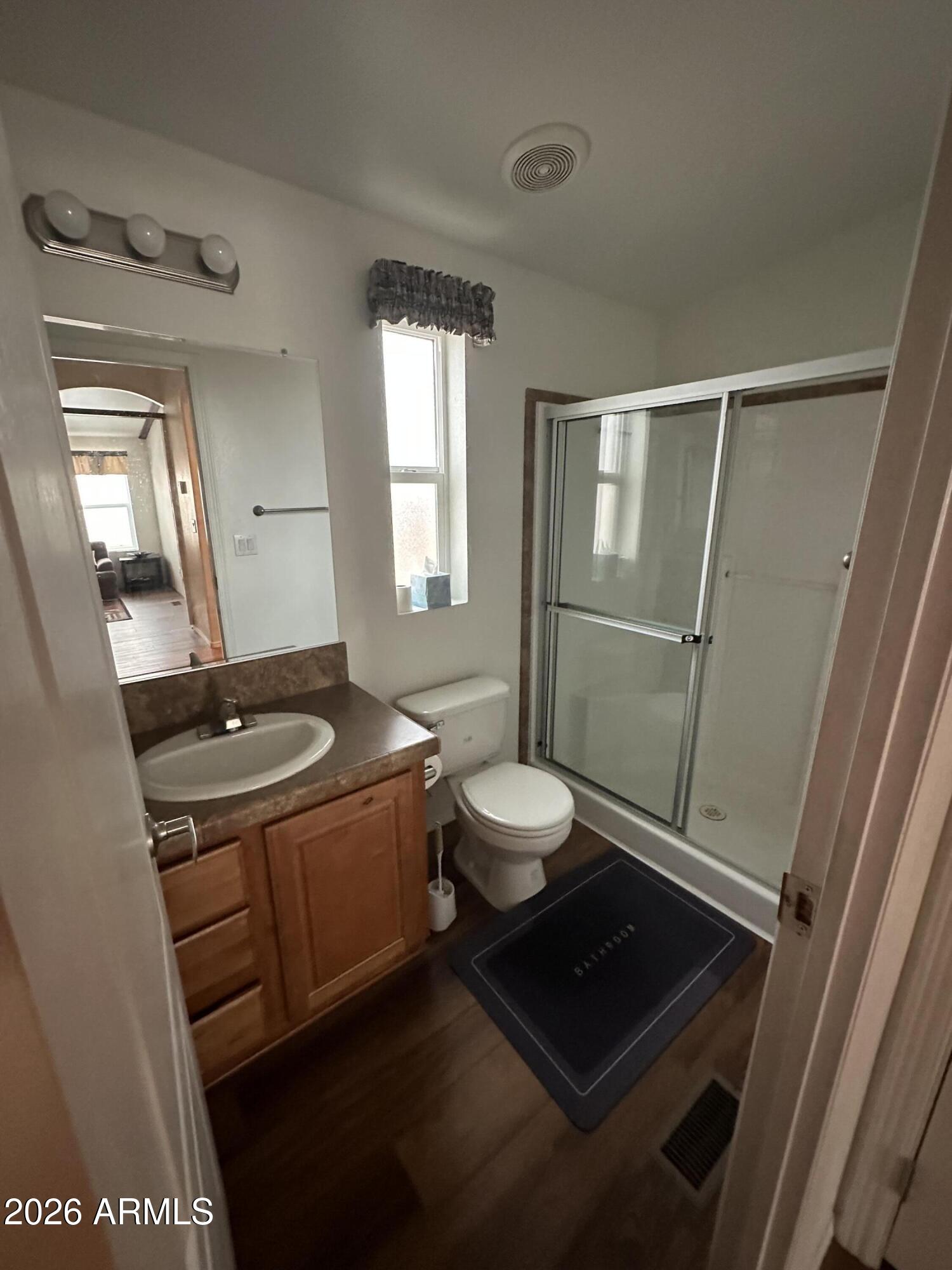 17200 West Bell Road, Unit 1658 Surprise, AZ 85374 - Photo 11 of 16 a bathroom with a sink a toilet a mirror and shower